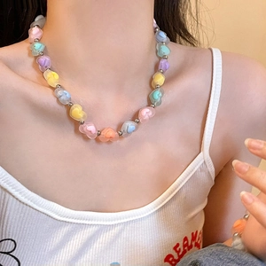 Détail rapproché des perles en forme de cœur colorées et des perles en argent du collier