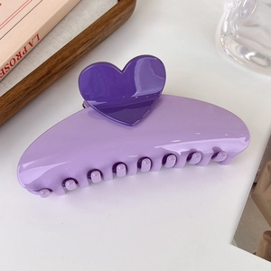Vue détaillée de la pince à cheveux en forme de cœur violette au fini brillant
