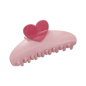 Pince à cheveux rose en forme de cœur pour chignon sur fond blanc