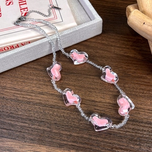 Détail de perles cœur roses et graines transparentes sur collier avec fermoir homard