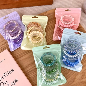 Cinque set di elastici per capelli a spirale colorati in sacchetti opachi con cerniera
