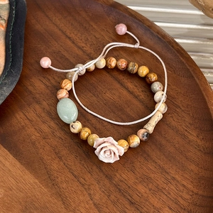 Detail of beaded rose bracelet with pink ceramic flower and yellow stone beads