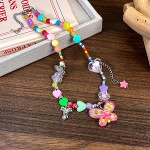 Détail du collier de perles Y2K coloré avec cœurs en résine et papillon rose