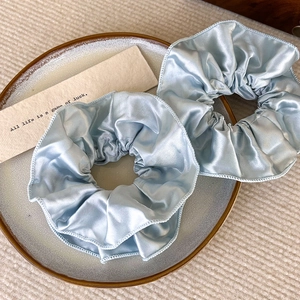 Zwei hellblaue Satin-Haargummis mit eleganten Doppelfalten in sanftem Pastellblau