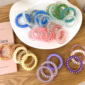 Dettaglio macro di elastici per capelli a spirale colorati con fantasie floreali miste