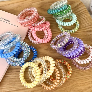 Dettaglio ravvicinato di elastici a spirale colorati con vari motivi floreali e a pois