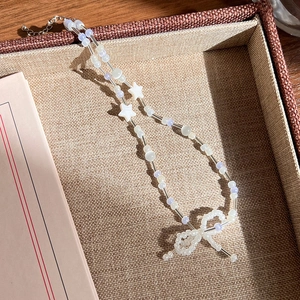 Détail d'un collier de perles colorées avec breloques étoiles et un nœud en perles