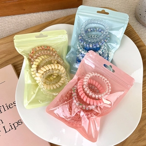 Dettaglio di elastici a spirale colorati con motivi floreali in confezioni opache