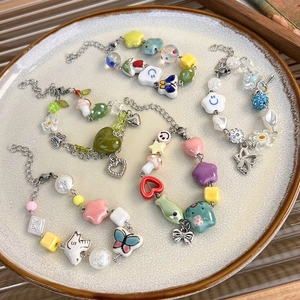 Set de quatre bracelets en perles de céramique colorées avec breloques papillon et cœur