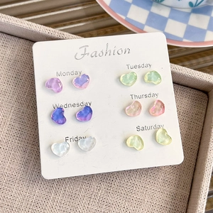 Close-up of heart-shaped resin stud earrings set in six vibrant colors on display card