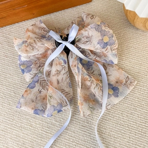 Détail de la pince à cheveux nœud en mousseline fleurie avec motifs floraux vintage