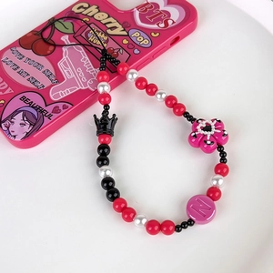 Close-up of Y2K beaded phone strap with black crown, pink flower charm and letter N bead