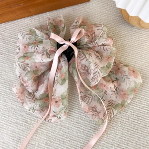Détail de la pince à cheveux avec nœud en mousseline florale et longs rubans roses