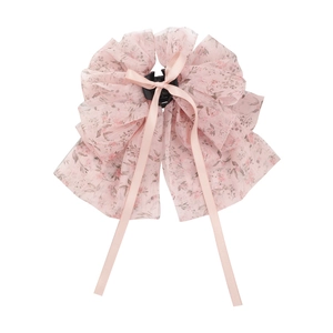 Pince à cheveux fleurie avec nœud en mousseline rose et longs rubans sur fond blanc