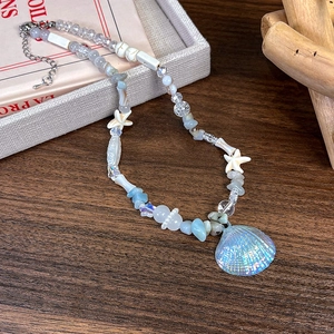 Vue détaillée du collier de perles style océan avec pendentif coquillage et étoile