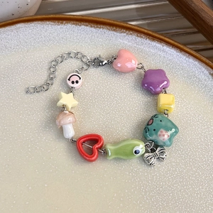 Vue détaillée d'un bracelet en céramique coloré avec pendentif papillon et perles
