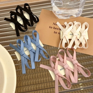 Detail view of double-layer ribbon bow hair clips in four elegant assorted colors