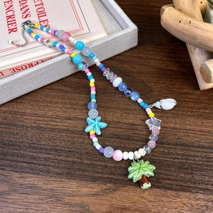 Vue détaillée d'un collier de perles d'été coloré avec charms étoile de mer et coquillage