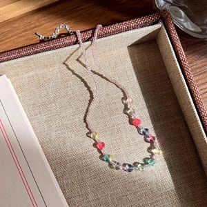 Détails des perles de cœur colorées et perles roses sur un collier de style vintage