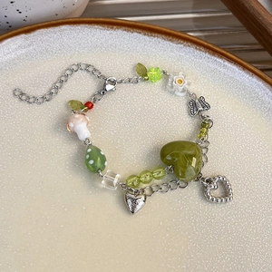 Détail du bracelet papillon en céramique colorée avec breloques champignon et cœur