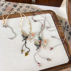 Macro shot of butterfly pendants with Chinese ink calligraphy and bead tassels