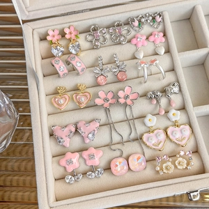 Macro detail of sweet pink heart flower earring set displayed in velvet jewelry box