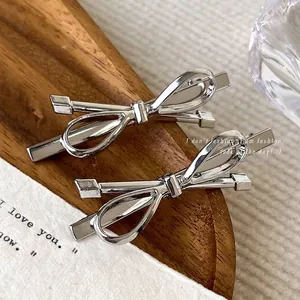 Set di fermagli per capelli a fiocco in metallo argento su un vassoio di legno elegante