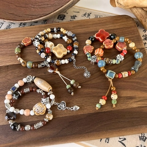 Detailed close-up of handmade ceramic and wooden beads with vintage tassels and alloy charms