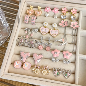 Detailed collection of pink enamel heart and flower earrings with rhinestones in a beige box