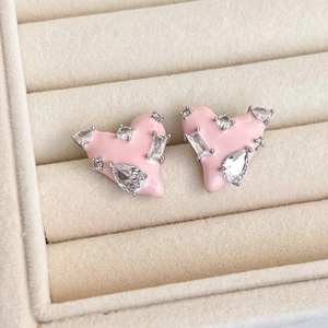 Detailed close-up of pink heart earrings with enamel finish and shimmering cubic zirconia