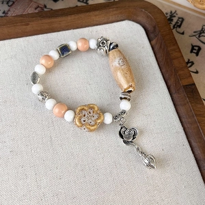 Macro shot of vintage ceramic beads with lotus charm and cloud pattern elements