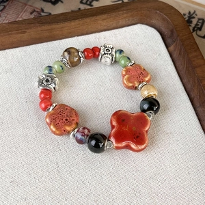 Detailed macro view of vintage Chinese ceramic beads with intricate silver floral spacers