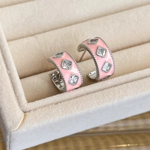 Detail of pink enamel C-shaped earrings with square zircon and silver beaded edges