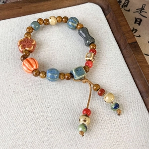 Macro view of handmade ceramic beaded bracelet with floral and pumpkin shaped charms