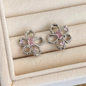 Close-up of pink flower earrings with heart crystals in a velvet jewelry box