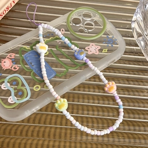 Detail of beaded phone strap with colorful cat paw beads and cute cartoon illustrations