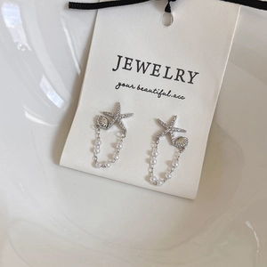 Boucles d'oreilles étoile de mer et coquillage avec strass et perles sur carte
