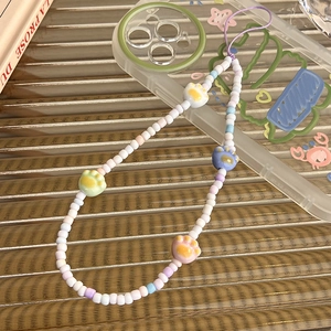 Detail of beaded phone strap with macaron-colored beads and three 3D cat paw charms