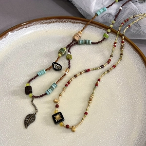 Detail of vintage bohemian beaded necklace with bronze leaf pendant and turquoise beads