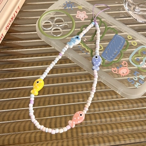 Detail of colorful beaded phone strap featuring cute ceramic fish pendants and summer theme
