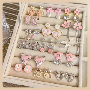 Pink heart and flower earrings set with rhinestones and pearls in a velvet jewelry box