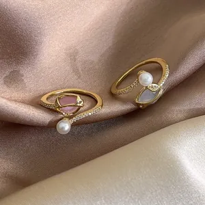 Detail of adjustable tulip pearl rings with micro-set diamonds on champagne silk