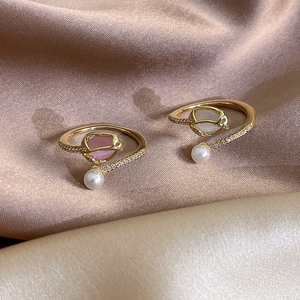 Elegant tulip pearl open rings with sparkling zircon inlay on warm gold satin fabric