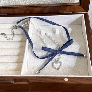 Double-layer denim choker with pearl beads, a fabric bow, and a sparkly heart pendant