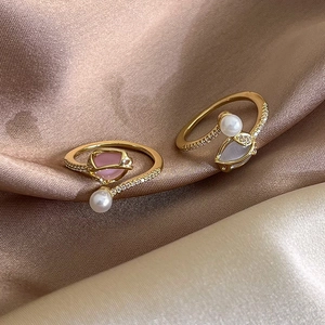 Detail of tulip pearl rings with pink and blue opal stones on golden satin
