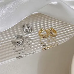 Minimalist gold and silver hoop earrings with quilted metal texture on ribbed glass