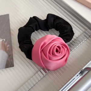 Détail d'un chouchou rose en satin en forme de rose sur un plateau argenté de style français