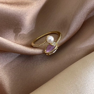 Detailed macro view of tulip pearl ring featuring purple cat eye stone and cubic zirconia