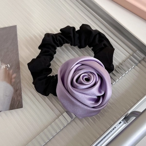 Gros plan détaillé d'un grand chouchou rose en satin violet sur un plateau argenté
