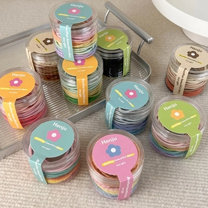 Detail of colorful high-elastic hair ties in a clear jar with a decorative brand label